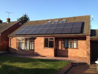 Brick bungalow with a row of solar panels on the roof